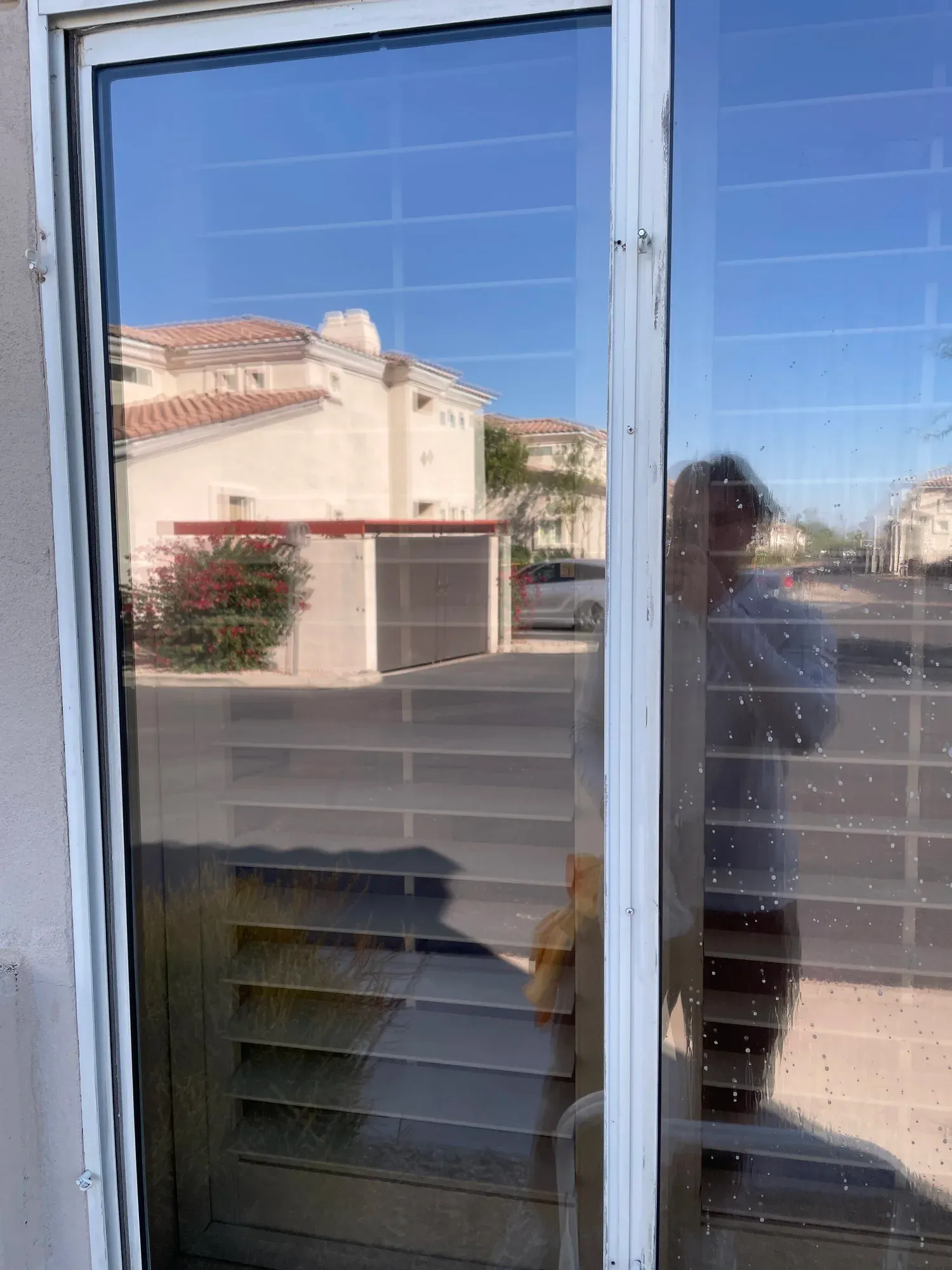 Sliding-glass cleaning in progress with wet glass beside a clear pane